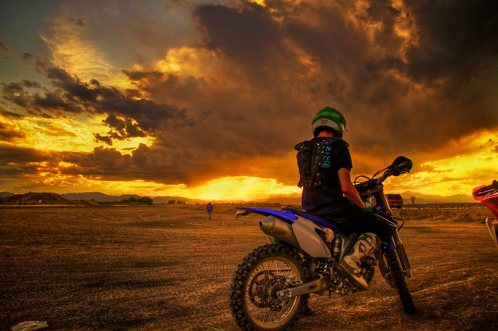 A dirt bike rider who is looking at a Colorado Springs sunset.